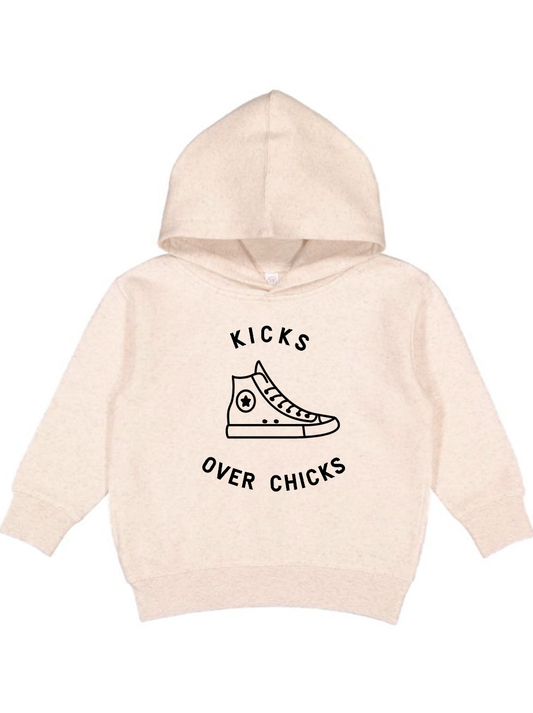 Beige hoodie with a sneaker graphic and "Kicks Over Chicks" text for a trendy streetwear look.